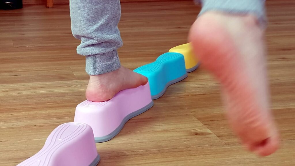 Ein Kind balanziert auf Kunststoffklötzen